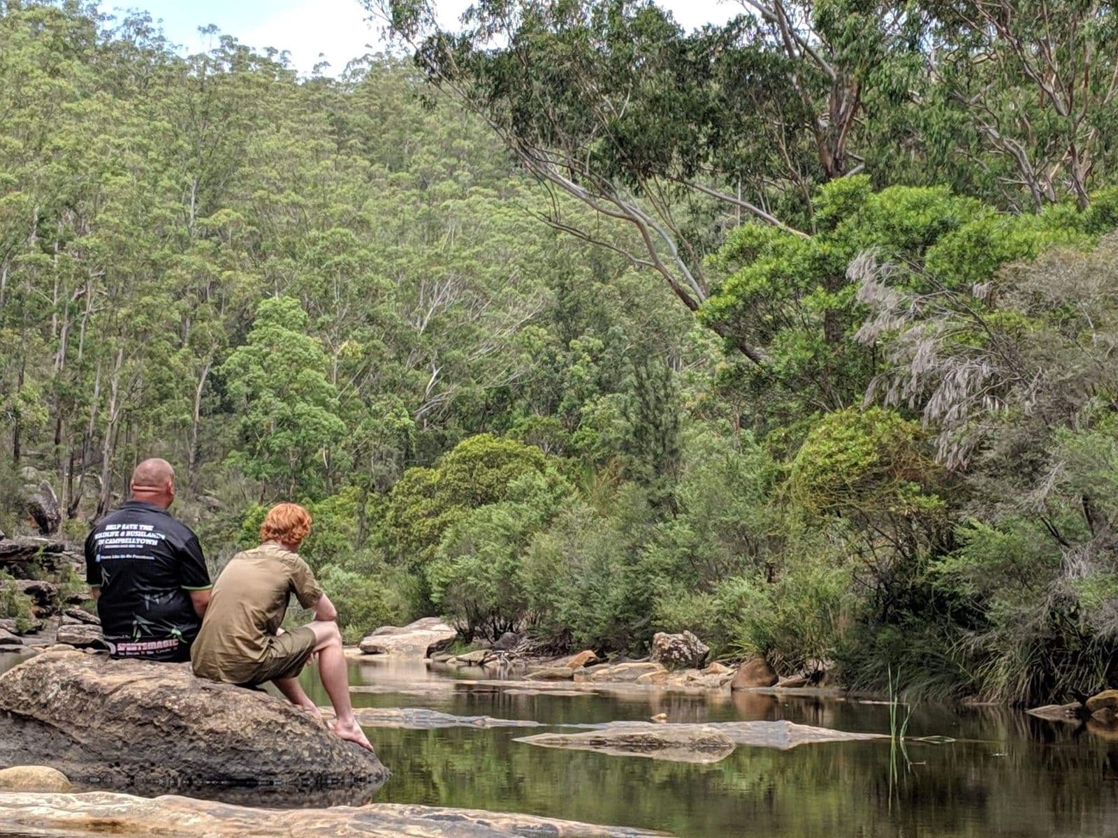 An ecologist on a rock platform beside a creek